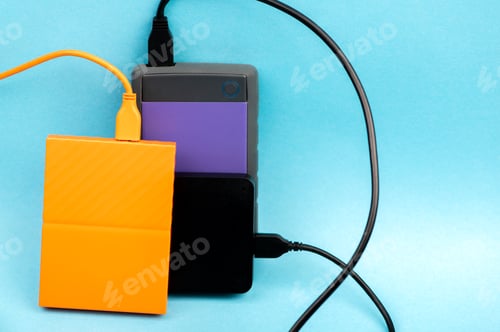 Preview: Three external portable hard disk drives isolated on light blue background