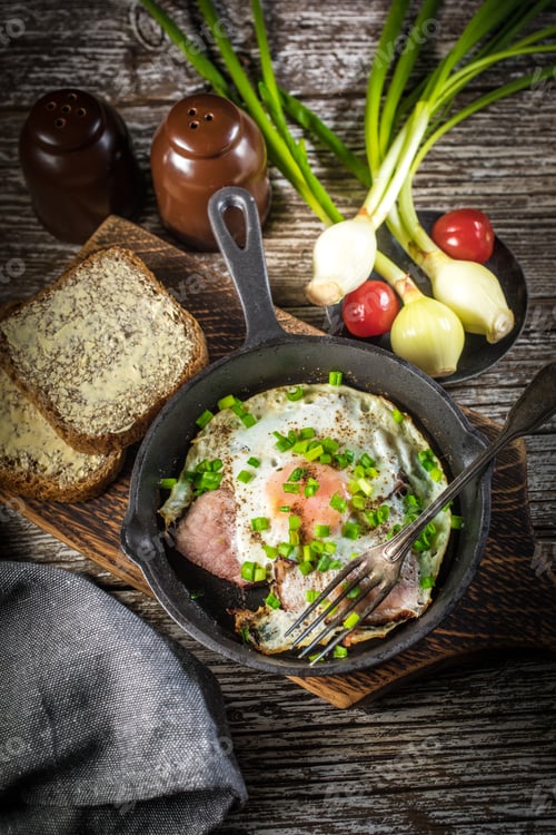 Preview: Fried eggs with ham on an old wooden background.