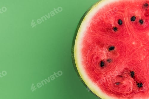 Preview: Watermelon Sliced in Half, Top View on Green Pastel Background