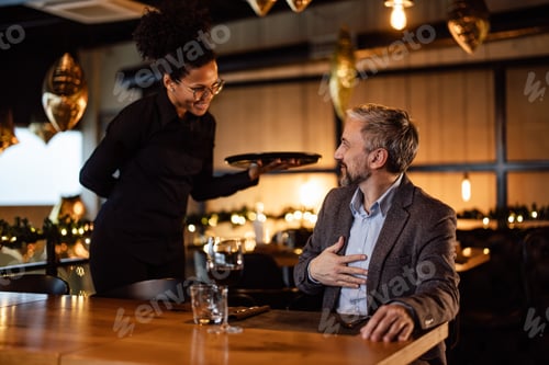 Preview: Friendly Waitstaff Serving a Content Gentleman in an Elegant Restaurant Setting
