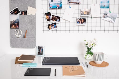 Preview: Workplace of designer by wall with folded laptop and other supplies on desk