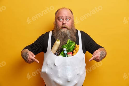 Preview: Shocked impressed bald man has food addiction, problem of overeating and obesity, points at bought p
