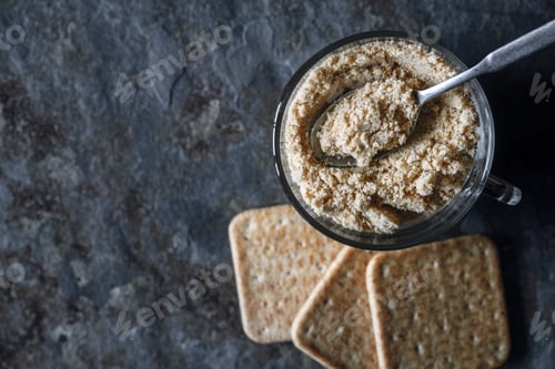 Preview: Cracker crumbs in the glass cup on the stone table top view
