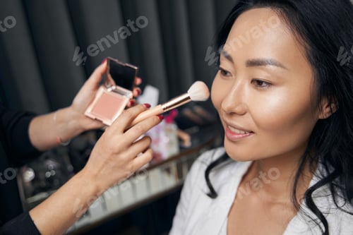 Preview: Unrecognized visagiste working with attractive female client