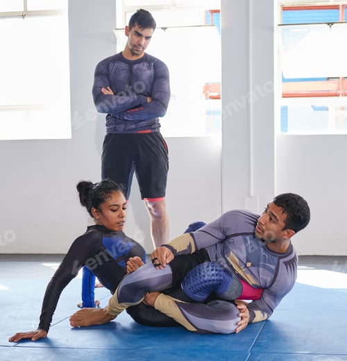 Preview: Full length shot of a jiu jitsu sensei sparring with one of his students during a class