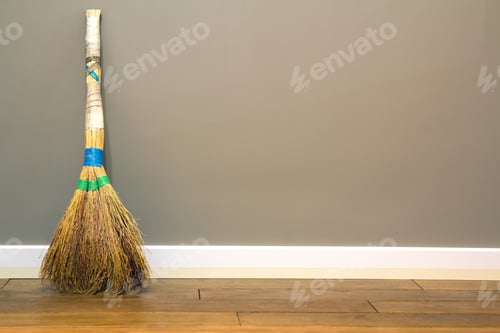 Preview: Yellow straw broom leaning to empty room wall