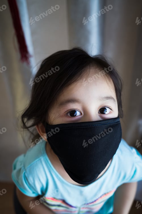 Preview: little girl looking up while wearing black fabric face mask