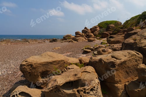 Preview: Rocky Beach with Large Boulders and Clear Blue Sky