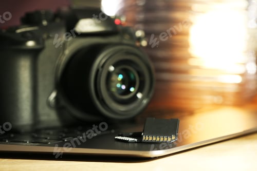 Preview: SD memory cards, laptop and photo camera on table, closeup