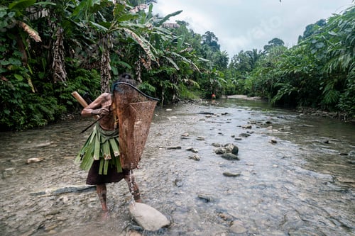 Preview: Indigenous man standing in river stream of amazon