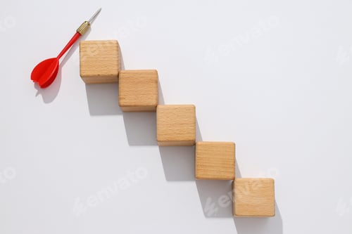 Preview: Five wooden cubes and red dart on white background