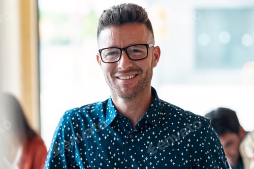 Preview: Handsome mature entrepreneur looking at camera in coworking place.