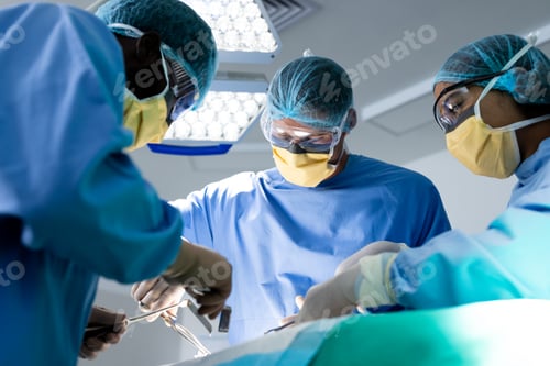 Preview: Diverse group of surgeons operating on patient in operating theatre