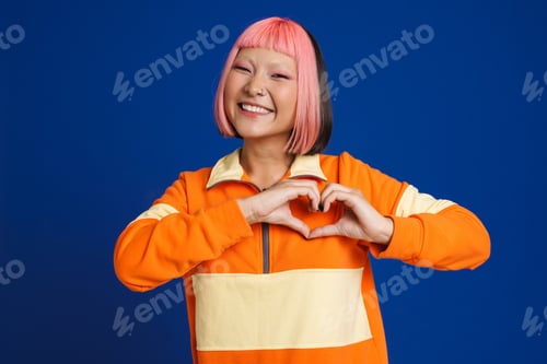 Preview: Asian girl with pink hair laughing and showing heart gesture