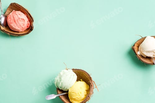 Preview: Coconut shells with fresh natural colorful ice-cream on a light green background