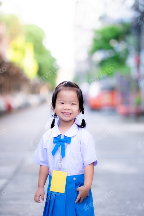 Preview: Girl wearing a school uniform smiled sweetly on the road in front of the house.