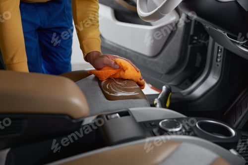 Preview: detailing worker washing leather car interior parts at professional auto service