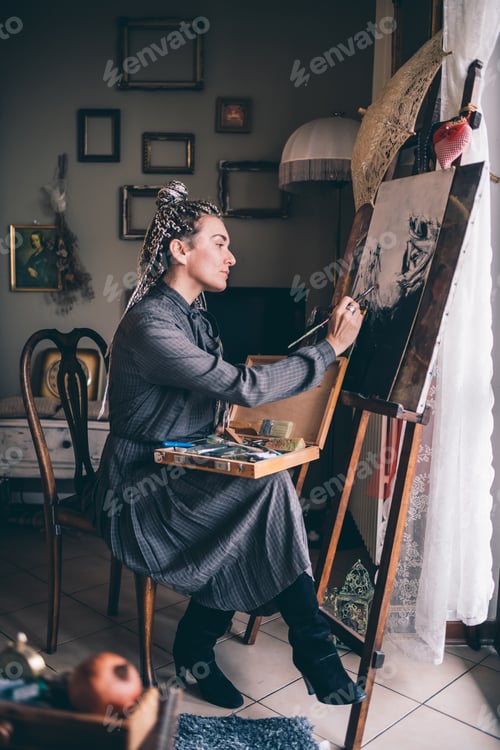 Preview: Adult woman indoors at home painting on canvas