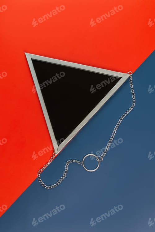 Preview: top view of triangle mirror in silver frame on a color blue and red background. Creative backdrop