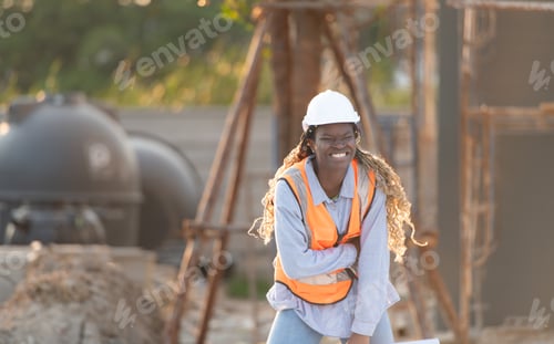 Preview: At the building site, a female engineer holds a blueprint in hand.