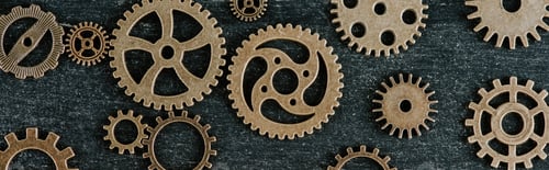 Preview: top view of vintage metal gears on dark wooden background, panoramic shot