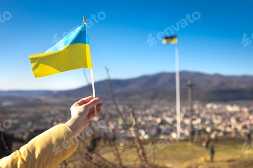 Preview: Flag of Ukraine in female hands against the sky.