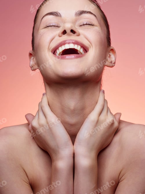Preview: Portrait of a joyful woman with hands on face and neck smiling at camera in a relaxed pose