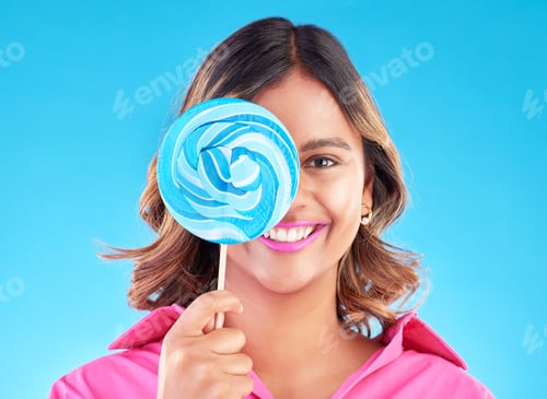 Preview: Portrait, lollipop or happy woman on a blue background in studio with positive, sugar or cheerful s