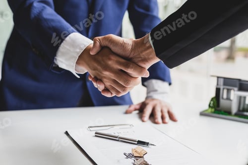 Preview: Businessman and real estate agent shaking hands after negotiating home purchase agreement.