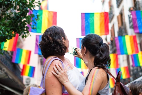Preview: Women taking pictures during gay pride parade with rainbow flags