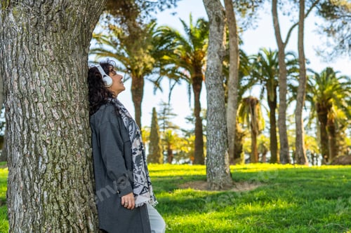 Preview: Happy woman enjoying nature listening music in park