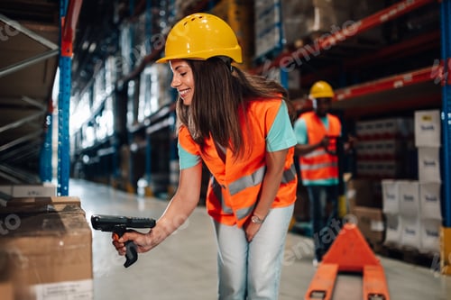 Preview: Female warehouse worker scanning packages with barcode scanner