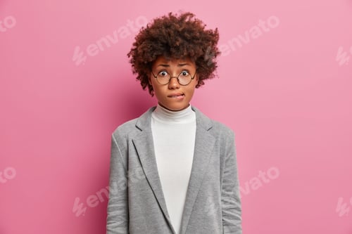 Preview: Nervous puzzled woman banker bites lips and worries about important event dressed formally wears rou