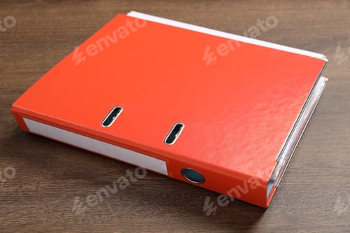 Preview: Orange hardcover office folder on wooden table, closeup
