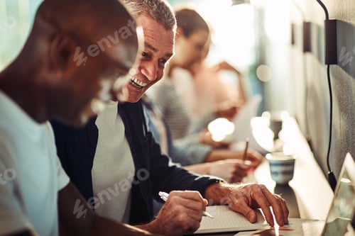 Preview: Diverse colleagues laughing together while working in an office