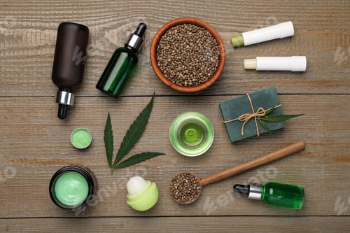 Preview: Hemp cosmetics and green leaves on wooden table, flat lay