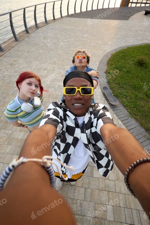 Preview: Portrait of Diverse Teenagers Taking Selfie Outdoors near Waterfront Promenade
