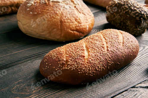 Preview: Different types of bread loaves on dark wooden background