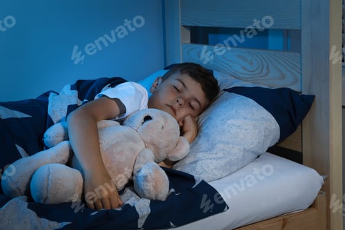 Preview: Cute little boy sleeping with teddy bear at home. Bedtime