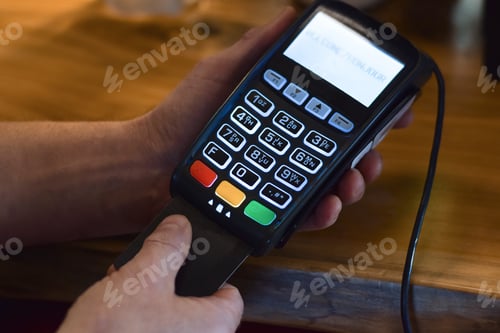 Preview: Man’s hand using payment terminal to make debit or credit card chip payment