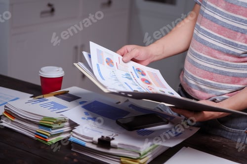 Preview: A man sits at his desk at home at night, working on his laptop. He views charts, checks documents