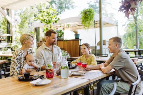 Preview: Big family with children and small baby at family dinner in restaurant. A small family celebration