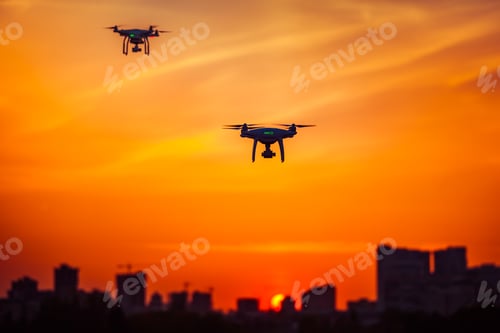 Preview: Two modern Remote Control Air Drones Fly with action cameras in dramatic orange sunset sk