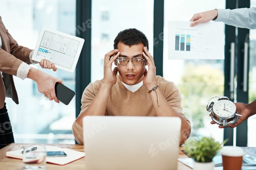 Preview: Shot of a young businessman looking stressed out in a demanding office environment