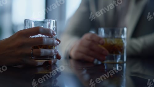 Preview: Colleagues hands drinking whiskey in restaurant closeup. Informal meeting