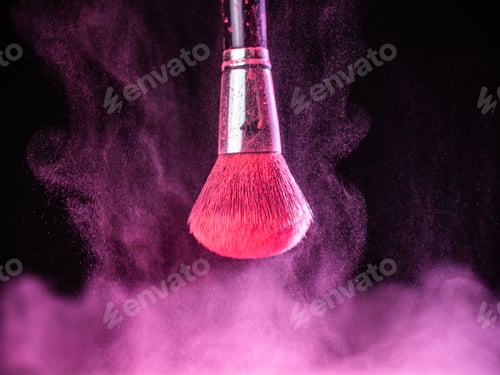 Preview: Make-up brush with pink powder splashes explosion on black background. Beauty concept