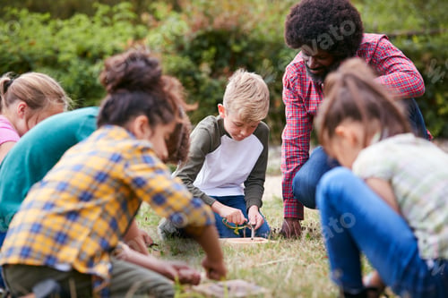 Preview: Team Leader Showing Group Of Children On Outdoor Camping Trip How To Make Fire