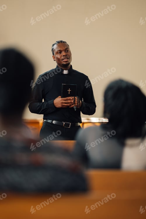 Preview: Young priest holding bible giving sermon in church