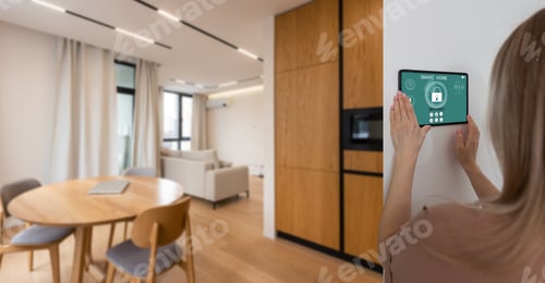 Preview: Side view pleasant young woman using smart home system or activating modern alarm system before