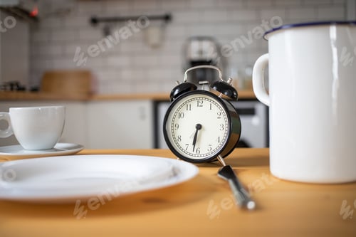 Preview: intermittent fasting concept alarm clock on kitchen table